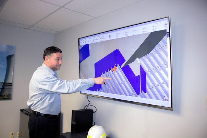 Man Pointing To Project Management For Complex Fabrication On Screen